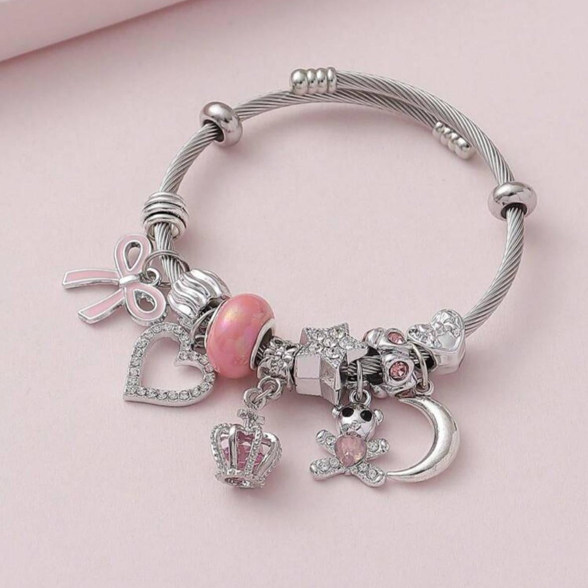 Pulsera con Dijes / Charms Plateados y Rosados Lazo, Corazón, Luna, Peluche y Corona